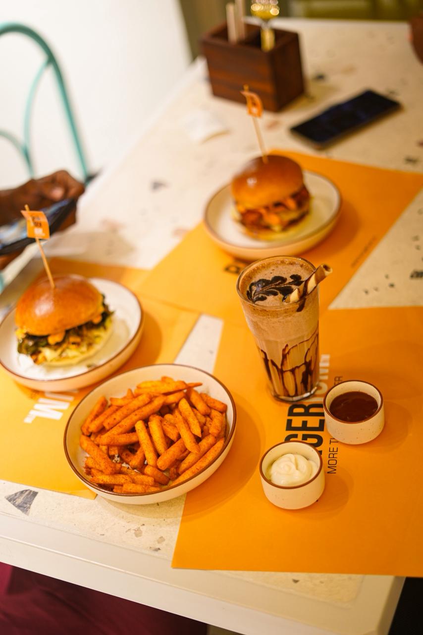 Burgerium burgers, fries, sauces, and a shake served on the table